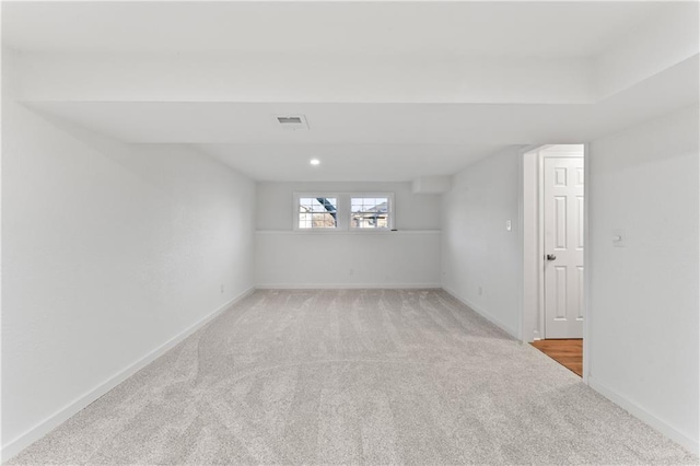 spare room with carpet, visible vents, and baseboards