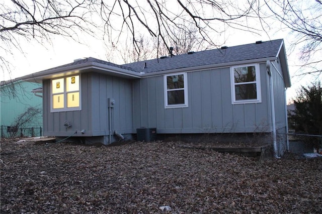 rear view of house featuring board and batten siding and a shingled roof