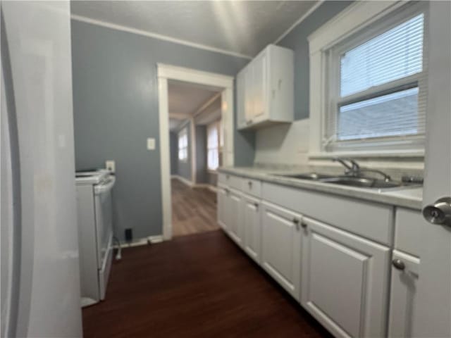 kitchen featuring white electric stove, dark wood finished floors, white cabinets, light countertops, and a sink