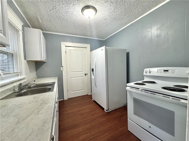 kitchen featuring white appliances, white cabinetry, light countertops, and a sink