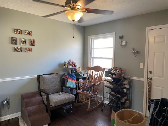 sitting room featuring ceiling fan, baseboards, a textured ceiling, and wood finished floors