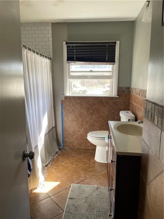 bathroom with vanity, a shower with shower curtain, tile patterned flooring, tile walls, and toilet