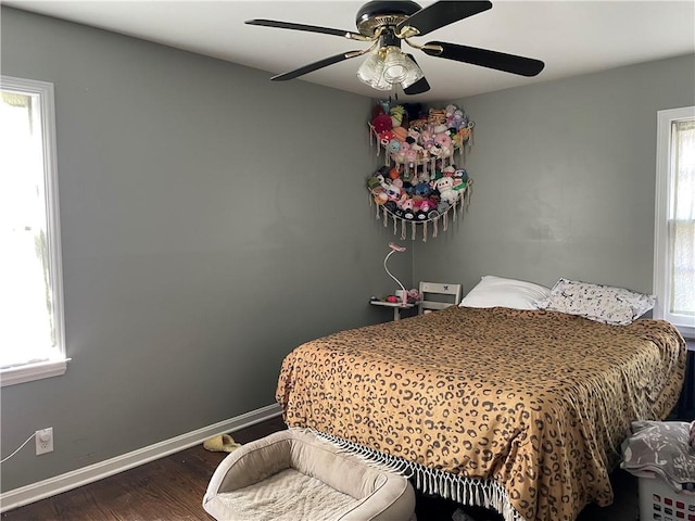 bedroom with ceiling fan, baseboards, and wood finished floors