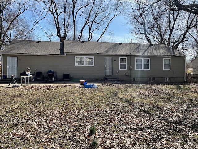 back of property featuring fence, roof with shingles, and a patio area