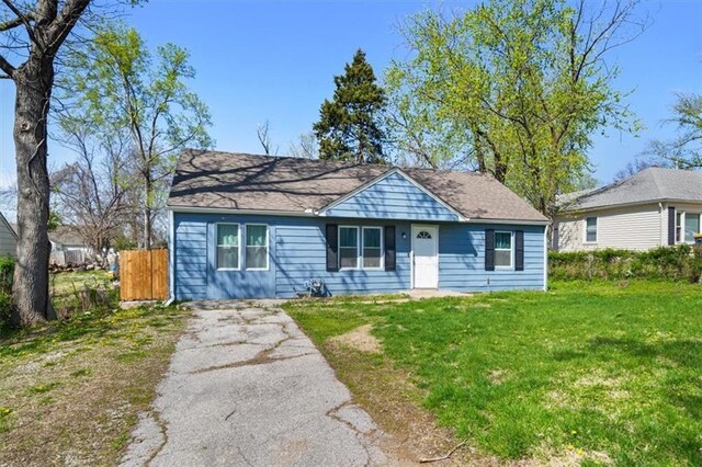 7408 E 57th St, Kansas City, MO 64129 - bungalow-style home with a front lawn and driveway