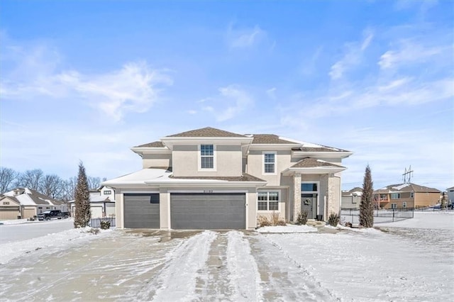 prairie-style home featuring a garage, fence, and stucco siding