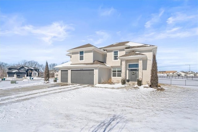 prairie-style home with fence, an attached garage, and stucco siding