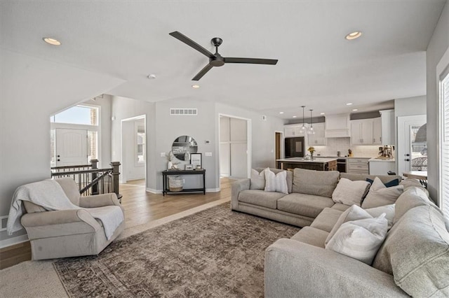 living room featuring recessed lighting, baseboards, visible vents, and light wood finished floors