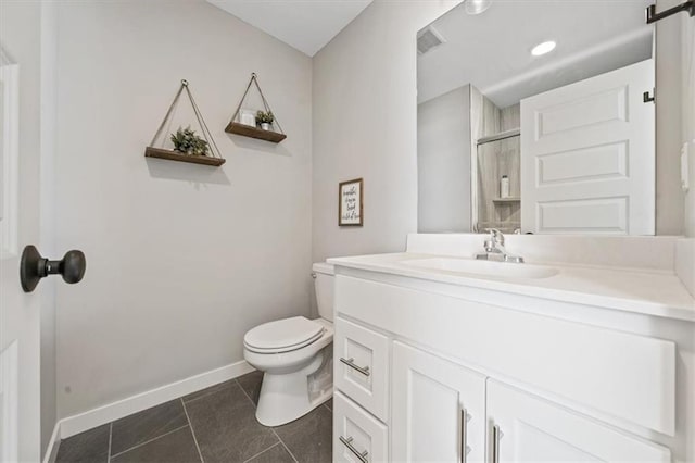 bathroom with toilet, visible vents, baseboards, vanity, and tile patterned floors