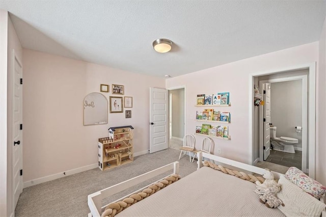 bedroom with carpet flooring, connected bathroom, and baseboards