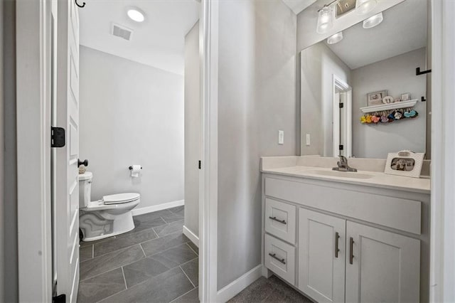 bathroom with toilet, visible vents, baseboards, and vanity