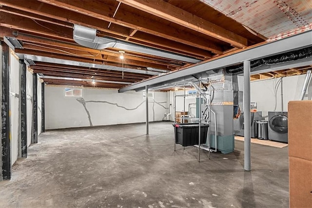 basement featuring heating unit and washer / dryer