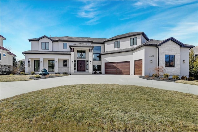 view of front of house with a garage, stone siding, driveway, stucco siding, and a front yard