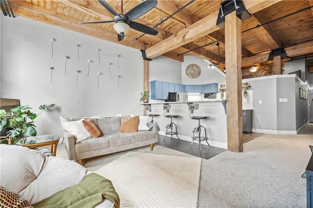 carpeted living area with ceiling fan, beamed ceiling, wooden ceiling, and baseboards