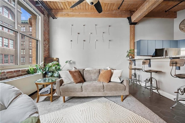 living room with wood ceiling, a ceiling fan, and beamed ceiling