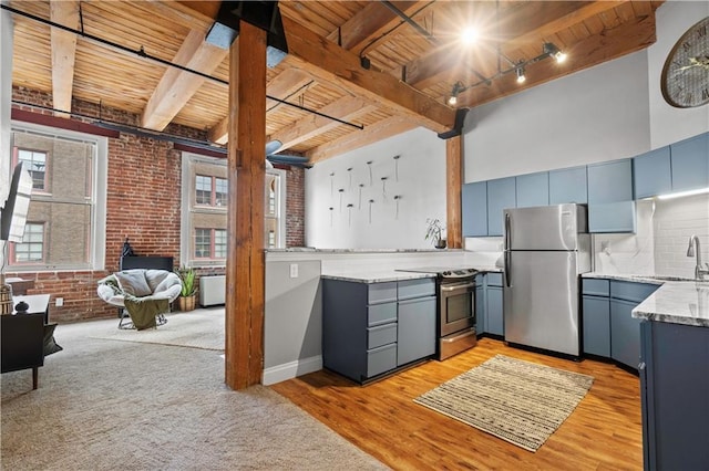 kitchen with open floor plan, stainless steel appliances, brick wall, and wood ceiling