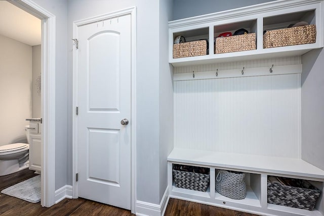 mudroom featuring dark wood-type flooring and baseboards