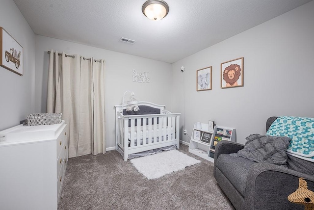 carpeted bedroom featuring visible vents, a textured ceiling, and baseboards