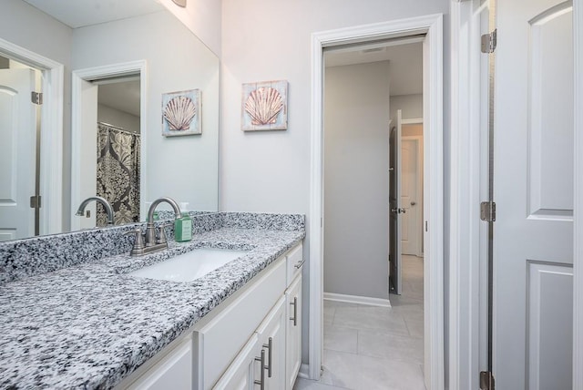 bathroom featuring tile patterned flooring, baseboards, and vanity