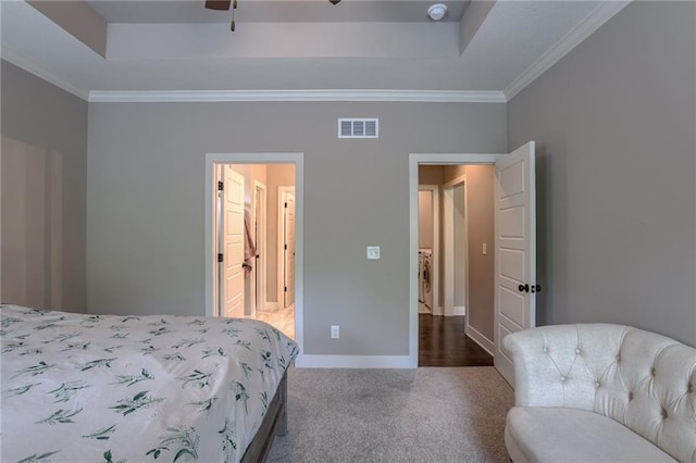 bedroom with a tray ceiling, carpet, visible vents, ornamental molding, and baseboards