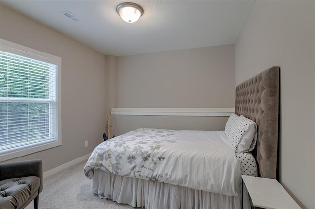 bedroom with light carpet, visible vents, and baseboards