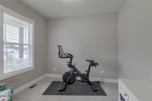 exercise area with light carpet, visible vents, and baseboards