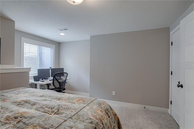 bedroom with a textured ceiling, carpet flooring, visible vents, and baseboards