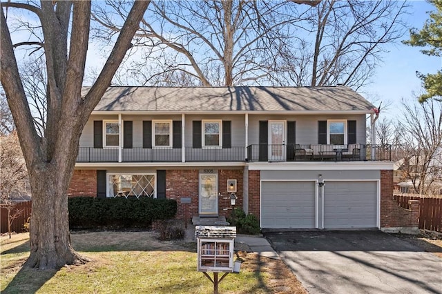 view of front facade with a garage, brick siding, aphalt driveway, fence, and a front yard