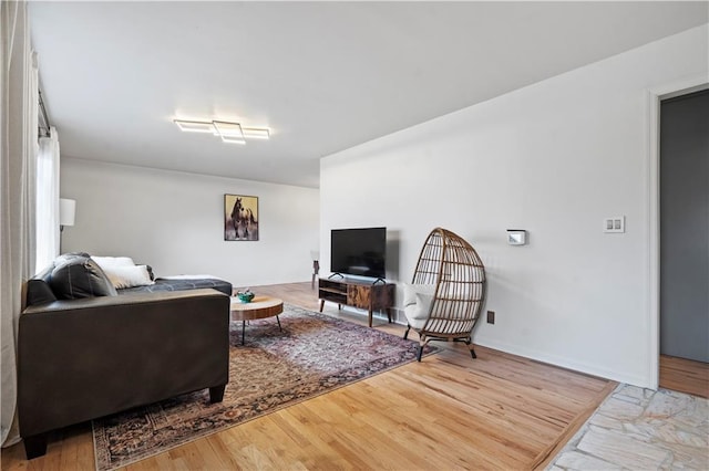 living area with baseboards and wood finished floors