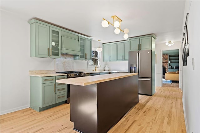 kitchen with custom exhaust hood, stainless steel appliances, and green cabinetry