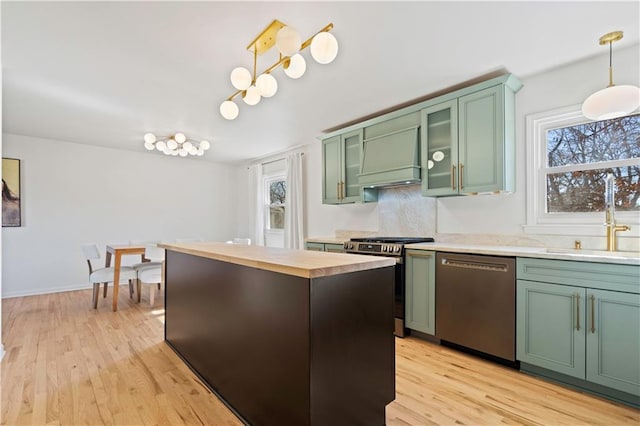 kitchen with butcher block countertops, appliances with stainless steel finishes, green cabinetry, and a sink