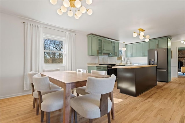 dining room featuring a chandelier, light wood-type flooring, and baseboards