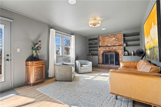 living room with a fireplace, wood finished floors, and crown molding