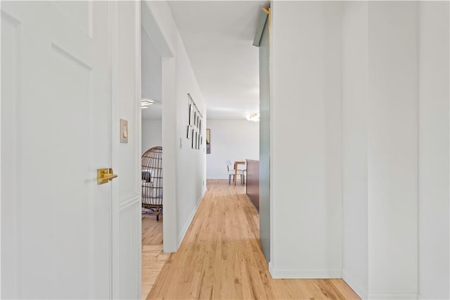 corridor featuring baseboards and light wood-style floors