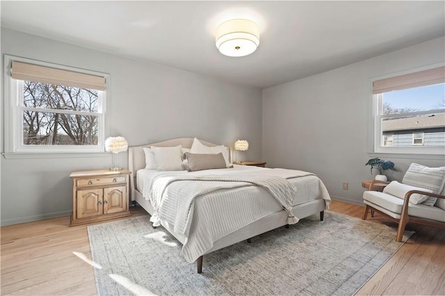 bedroom with light wood finished floors and baseboards