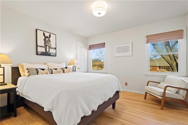 bedroom with light wood finished floors and baseboards