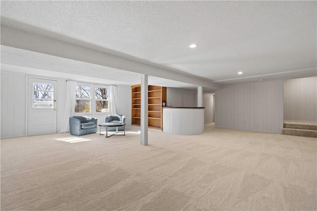 basement featuring recessed lighting, stairs, a textured ceiling, and light colored carpet