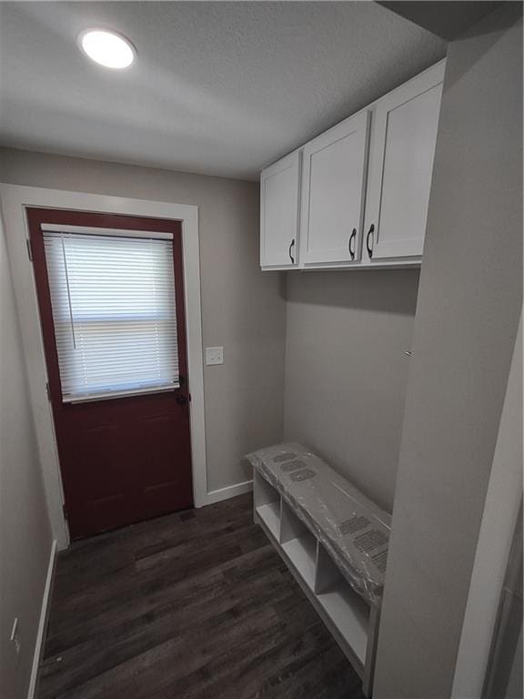 mudroom with dark wood-type flooring and baseboards