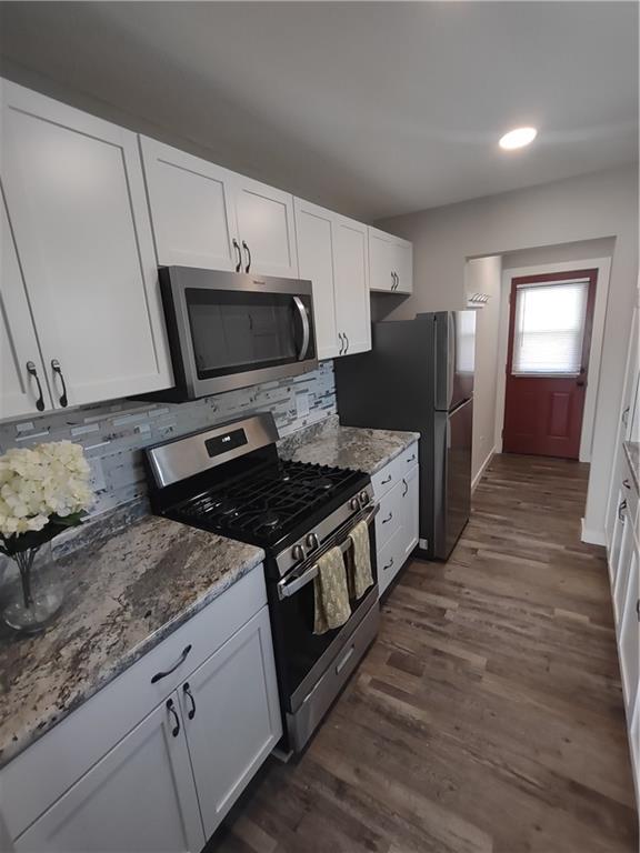 kitchen with appliances with stainless steel finishes, white cabinets, and decorative backsplash