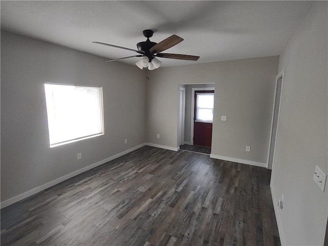 unfurnished room featuring ceiling fan, dark wood-type flooring, and baseboards