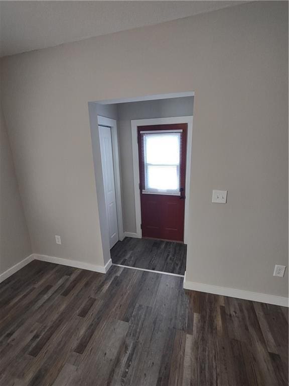 foyer entrance with baseboards and dark wood finished floors