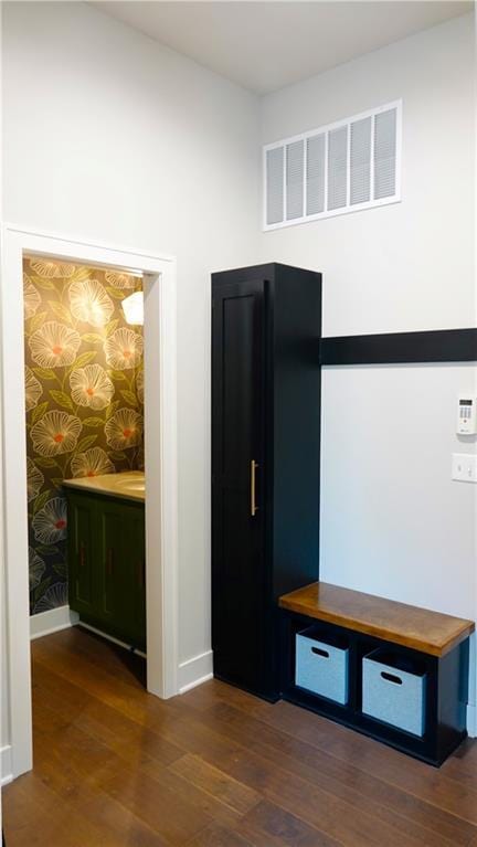 interior space featuring dark wood-type flooring, visible vents, and baseboards