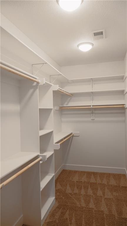 spacious closet with visible vents and dark carpet