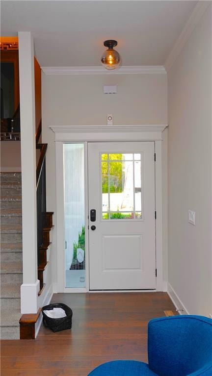 entrance foyer featuring stairs, ornamental molding, dark wood-style flooring, and baseboards