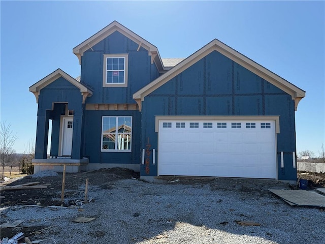 view of front of property featuring gravel driveway and an attached garage