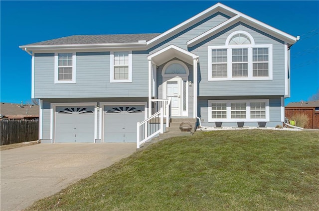 split foyer home featuring a garage, a front yard, fence, and driveway