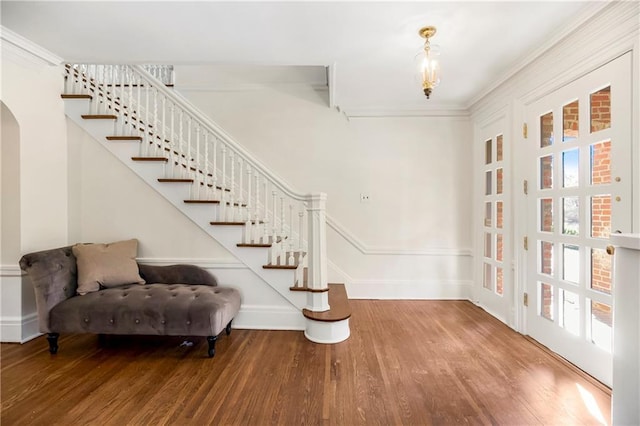 entryway featuring ornamental molding, stairway, baseboards, and wood finished floors