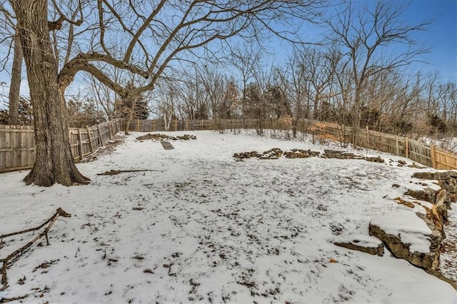 yard covered in snow featuring fence