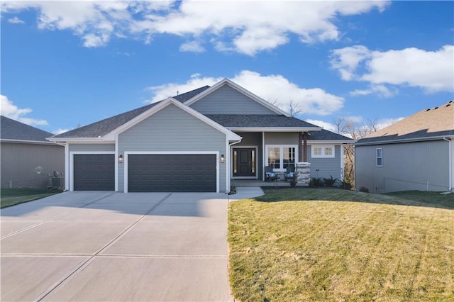 view of front of home featuring a garage, driveway, and a front yard