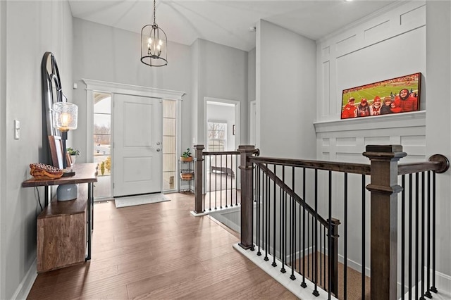 entrance foyer featuring a chandelier, baseboards, and wood finished floors